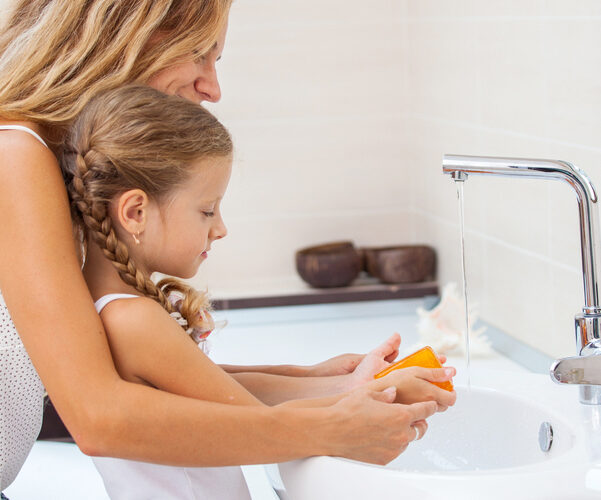 Mom and daughter at sink handwashing