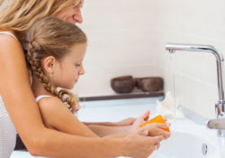 Mom and daughter at sink handwashing