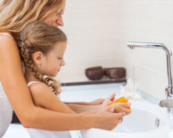 Mom and daughter at sink handwashing